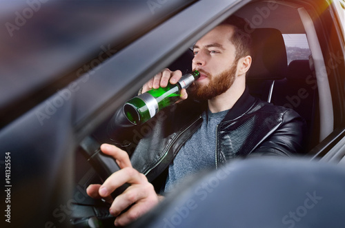 Drinks alcohol in the car. The guy with beer at the wheel. Man with beer. emergency situation. Social photo