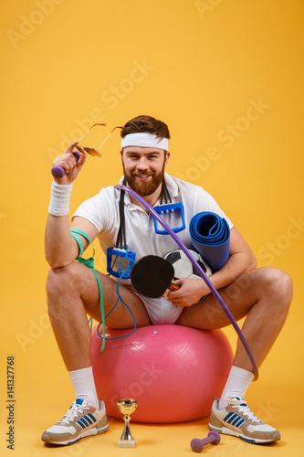 Portrait of a sports man sitting on a fitness ball photo