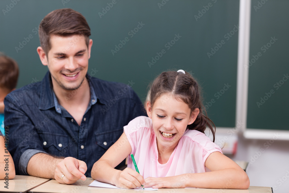 Lehrer gibt Hilfestellung in der Grundschule Lehrer gibt Hilfestellung in der Grundschule