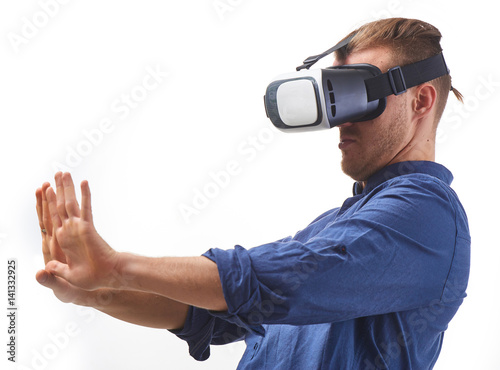 Young man Using VIrtual Reality Glasses for first time looking on his hand thru VR Glasses studio shot on white background