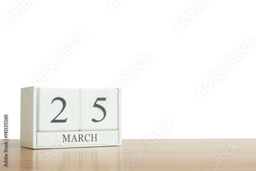 Closeup surface white wooden calendar with black 25 march word on blurred brown wood desk isolated on white background with copy space , selective focus at the calendar