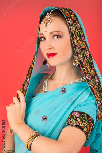 beautiful woman in Indian dress posing on red background