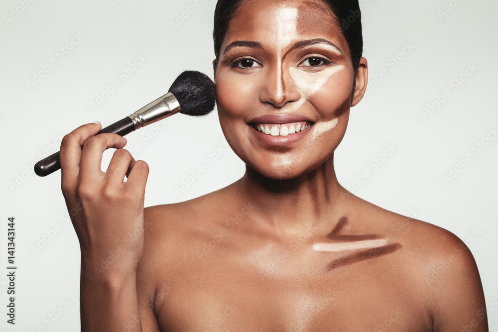 Beautiful young woman applying makeup Beautiful young woman applying makeup