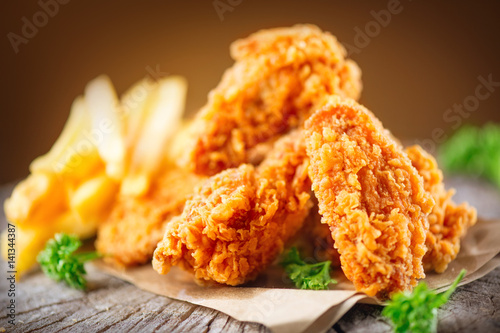 Fototapeta Crispy fried kentucky chicken wings on wooden table
