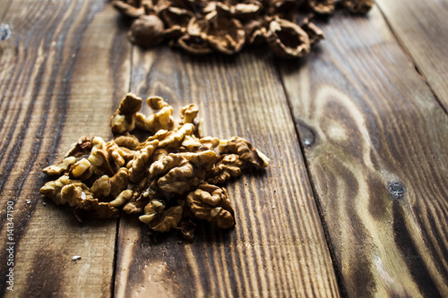 peeled walnuts and shell on wooden background