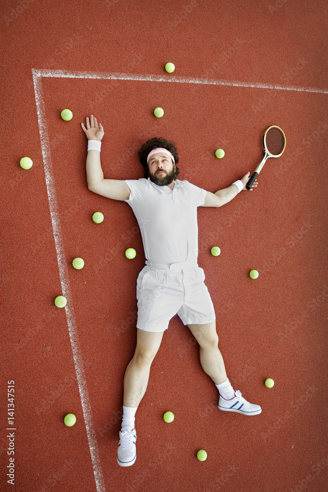 Tennis Fail, Tired man laying down, floored and defeated on the tennis  court, with lots of balls around him Stock Photo | Adobe Stock