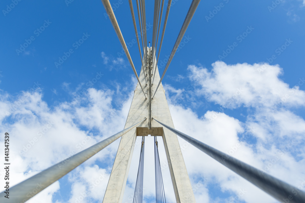 From below shot of bridge structure with wires on background of blue clear sky From below shot of bridge structure with wires on background of blue clear sky