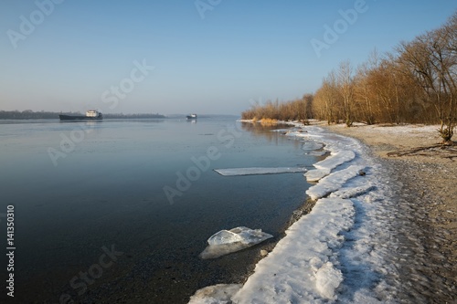 Cargo ship in beautiful frozen river. Aerial view. © kolidzei