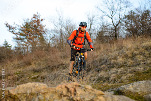 Enduro Cyclist Riding the Mountain Bike on the Rocky Trail. Extreme Sport Concept. Space for Text.