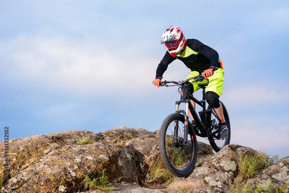 Professional Cyclist Riding the Bike on the Top of the Rock. Extreme Sport Concept. Space for Text. Professional Cyclist Riding the Bike on the Top of the Rock. Extreme Sport Concept. Space for Text.