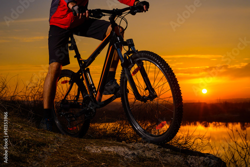 Enduro Cyclist Riding the Mountain Bike on the Rocky Trail at Sunset. Active Lifestyle Concept.
