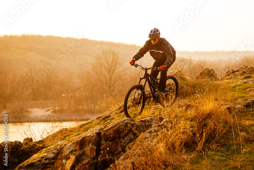 Fototapeta Naklejka Na Ścianę i Meble -  Enduro Cyclist Riding the Mountain Bike Down Beautiful Rocky Trail. Extreme Sport Concept. Space for Text.
