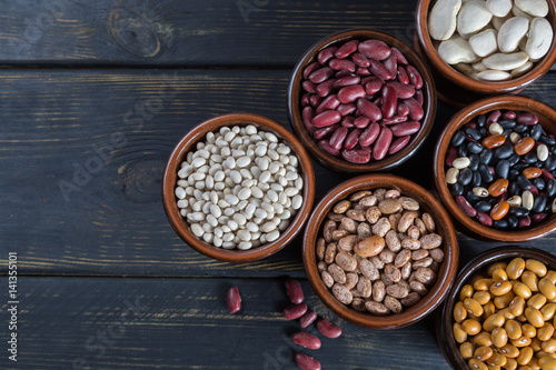 Assortment of beans on wooden background. Soybean, red kidney bean, black bean,white bean, red bean and brown pinto beans