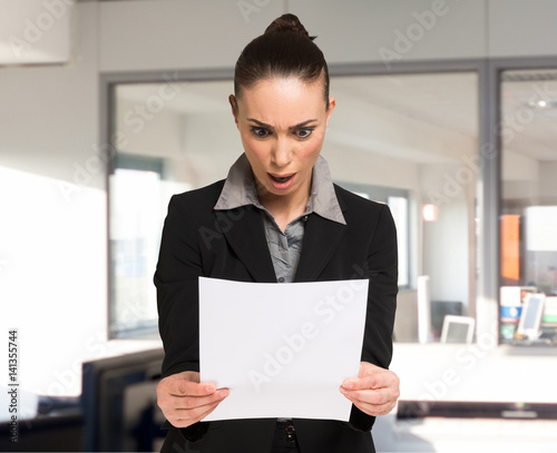 Canvas Print Surprised woman reading a business document