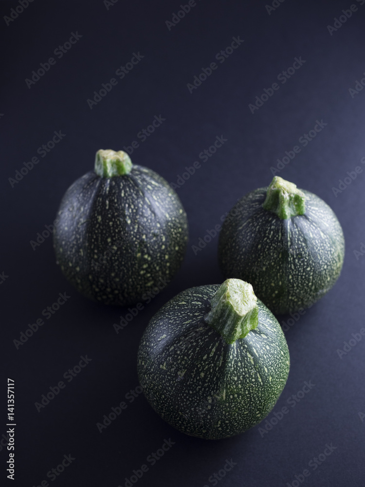 Round courgettes isolated on dark background Round courgettes isolated on dark background