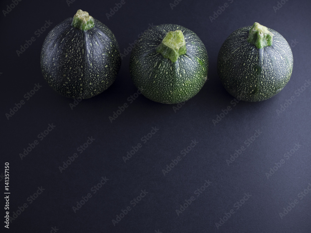 Round courgettes isolated on dark background Round courgettes isolated on dark background