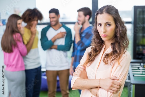Colleagues bullying a sad female executive © WavebreakMediaMicro