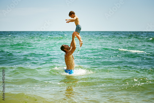 father playing with son at sea