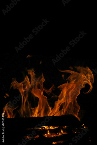 Fire flame isolated on black background. Bonfire with empty place for your design.