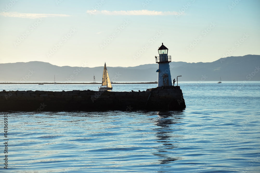 lighthouse and a boat in the marine