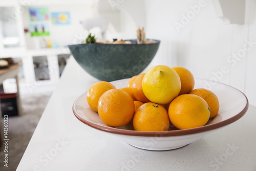 Bowl of fresh oranges on kitchen counter photo