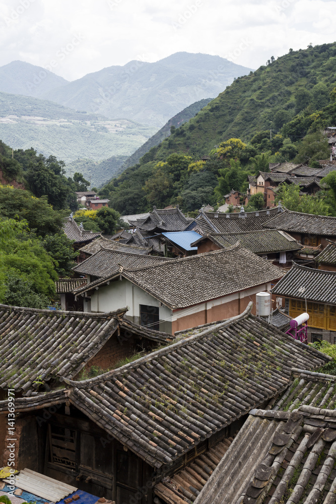 Traditional Chinese village in Yunnan province, view over roofs and valley Traditional Chinese village in Yunnan province, view over roofs and valley