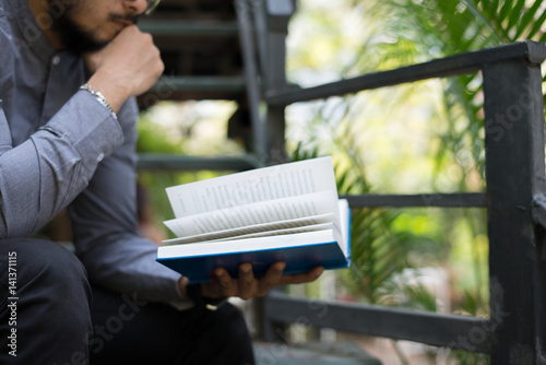 Young handsome beard man reading book. Learning or Education concept.