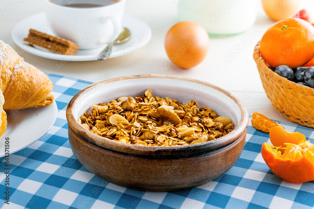 Healthy food for breakfast on a white wooden table. Oatmeal granola with nuts, coffee, croissants, eggs, milk and fruits for delicious healthy meal. Close-up shot. Healthy food for breakfast on a white wooden table. Oatmeal granola with nuts, coffee, croissants, eggs, milk and fruits for delicious healthy meal. Close-up shot.