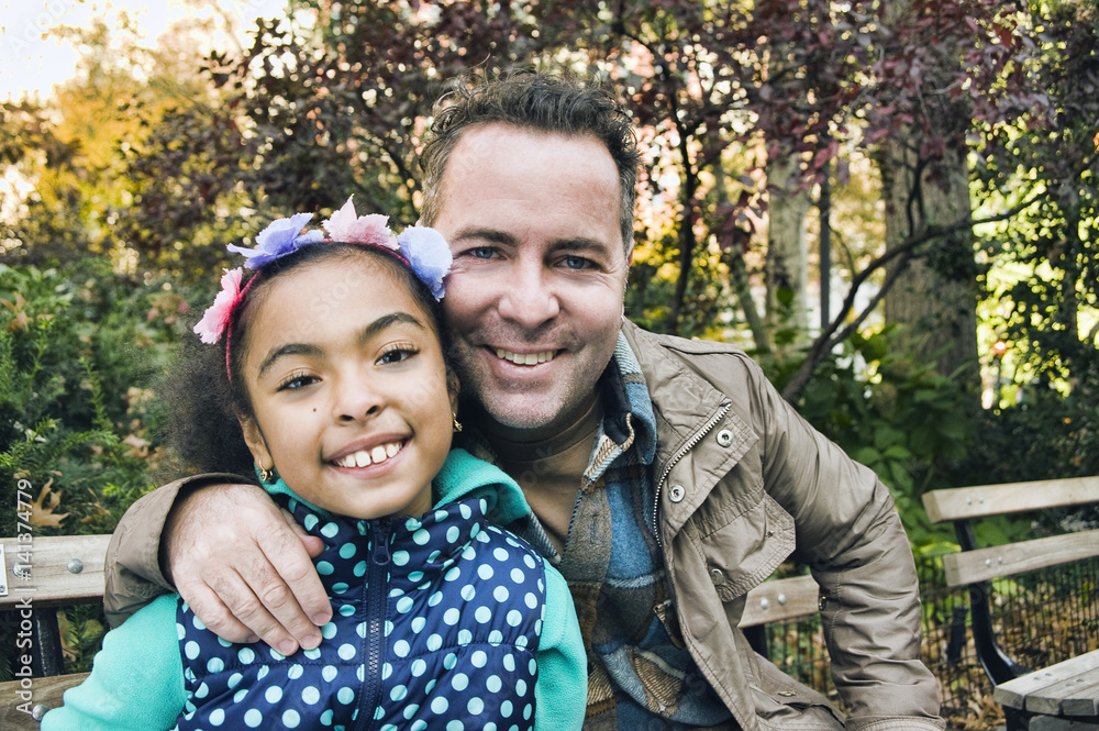 Father and daughter in park looking at camera smiling Father and daughter in park looking at camera smiling