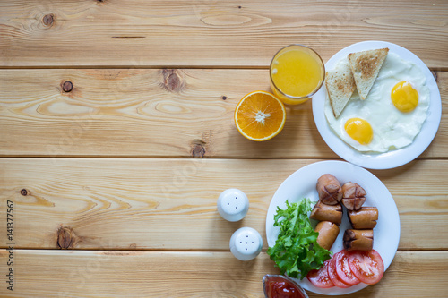 Orange juice, Two eggs and sausage for healthy breakfast.