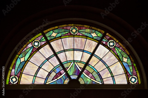 Circle top shaped window with elegant patterned stained glass.