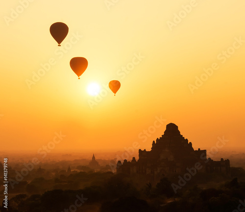 Hot air balloons in the morning sky on the background of the silhouette of old Buddhist temple in Bagan, Myanmar