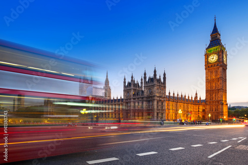 London scenery at Westminster bridge with Big Ben and blurred red bus  UK