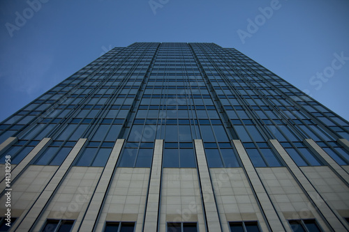 Tall concrete, glass and steel building surrounded by clear blue sky