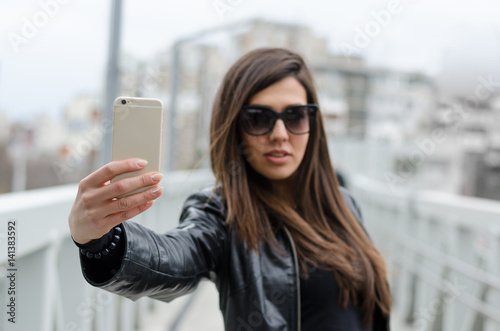 Portrait of a young attractive woman making selfie photo on smartphone