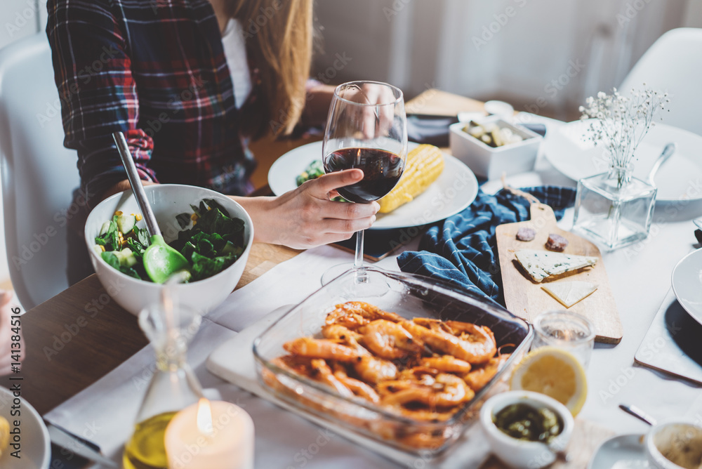 Happy hipster girl enjoying tasty mediterranean food, friends dinning homemade food and drinking red wine, celebrating and holidays concept, good moments