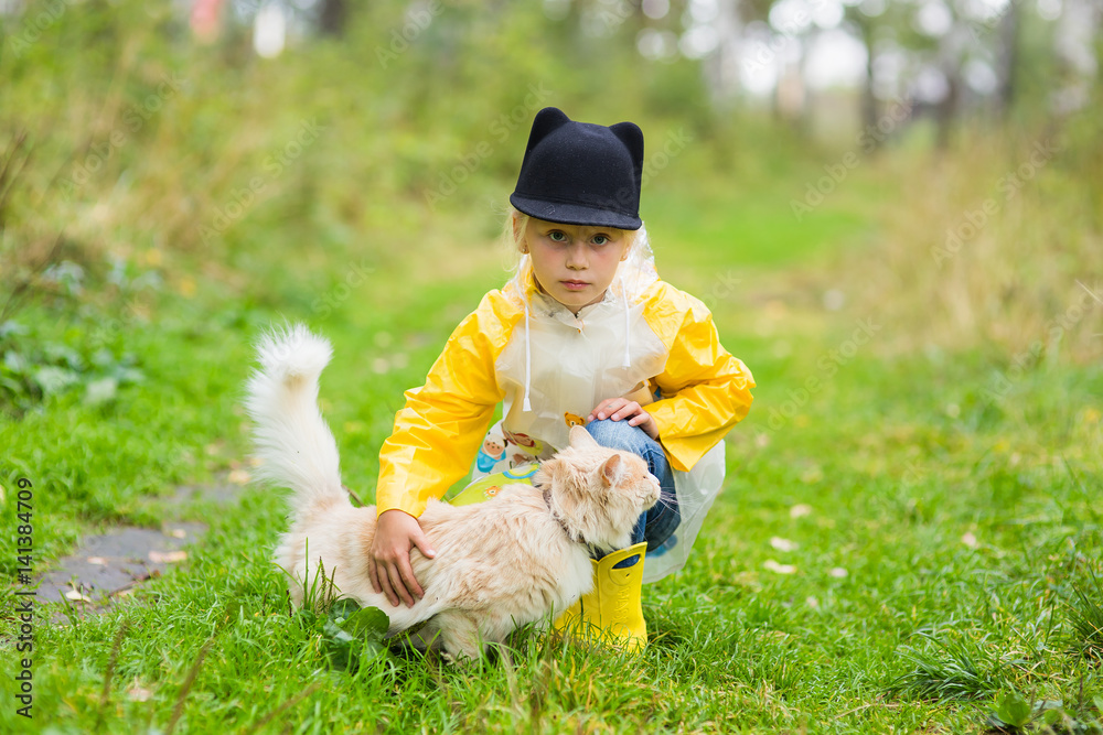 Little girl with homeless cat in autumn park. Concept of friendship Little girl with homeless cat in autumn park. Concept of friendship