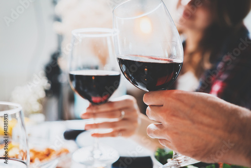 Romantic couple enjoying dinner at home, concept love, relationship and romantic, happy couple celebrating and making cheers with glasses of red wine