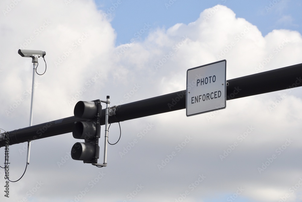 CCTV camera, traffic lights and photo enforced sign along the road