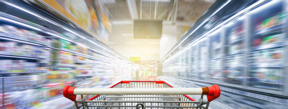 Supermarket aisle with empty red shopping cart - obrazy, fototapety, plakaty 