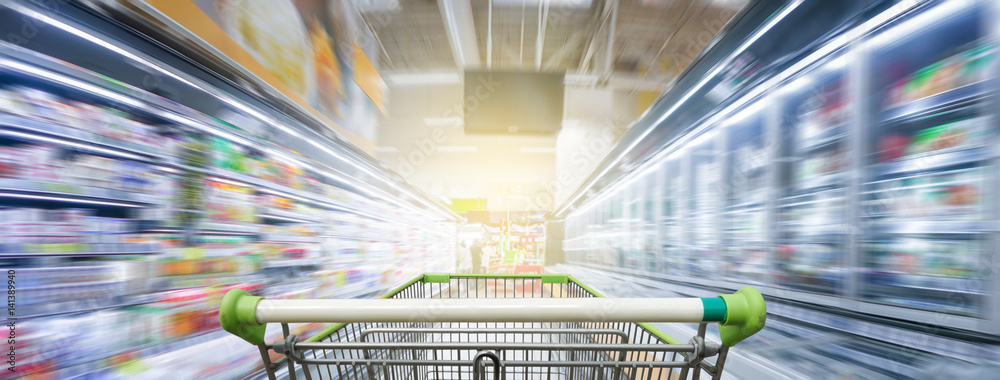 Supermarket aisle with empty green shopping cart - obrazy, fototapety, plakaty 