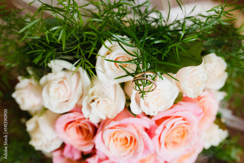 Flowers lie on a wooden table. Flowers closeup. Wedding rings lie on a bouquet