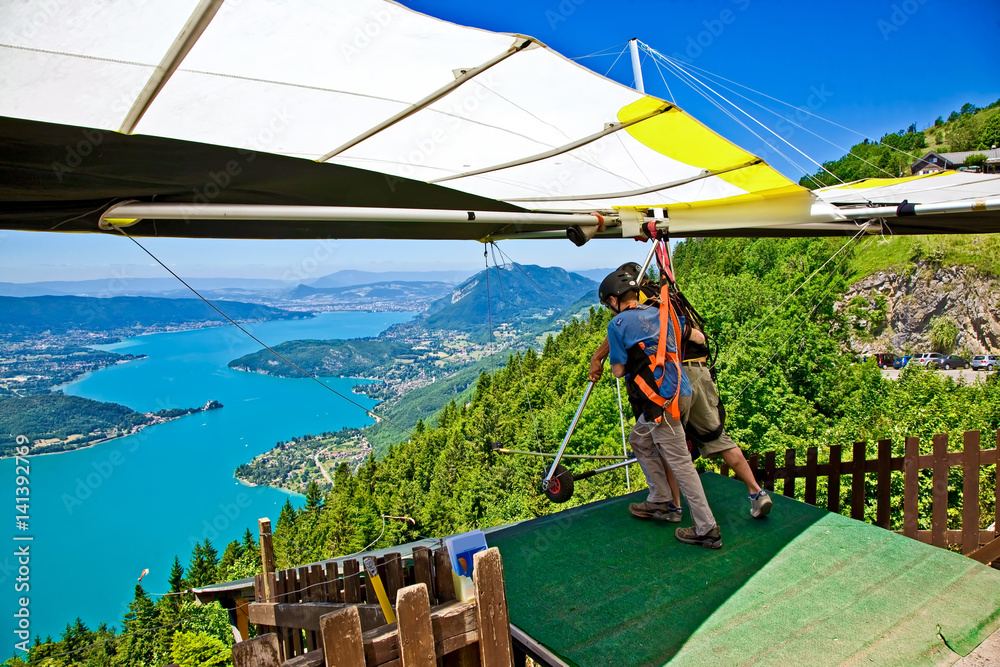 Fototapeta premium Hanggliding over Lac Annecy, France. Town of Annecy in the far distance. Town of Talloires on middle right.
