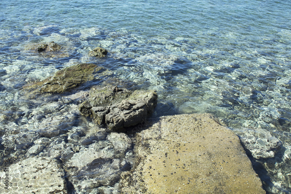 Close up view of crystal clear turqouise water with rocky - stone ground in Bodrum city.
