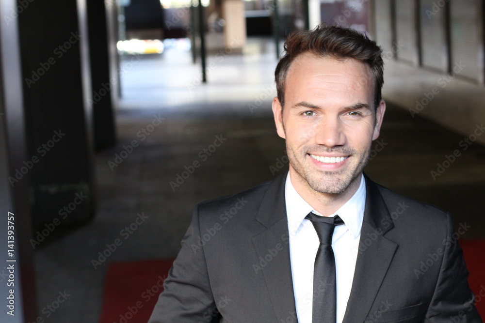 Smiley businessman walking outside the office building Smiley businessman walking outside the office building