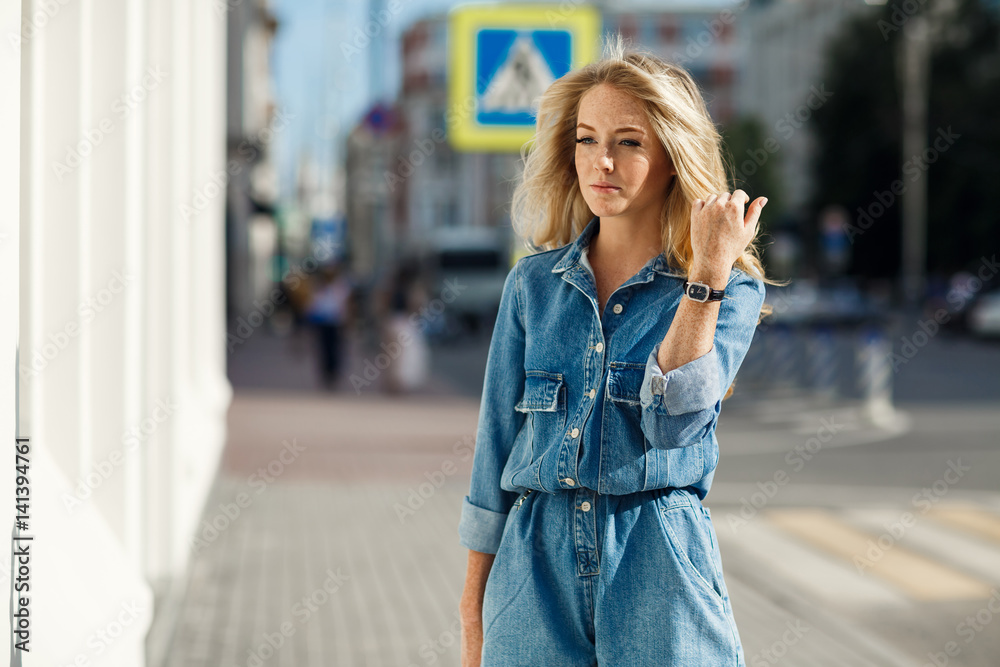 Fototapeta premium Street style. Beautiful woman walks on the street at the Moscow City at sunny spring day.