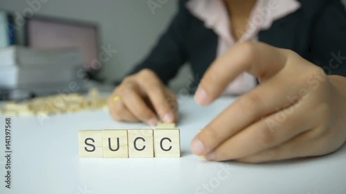 Female changing letter on wood block from suck to success concept for improvement to successfully