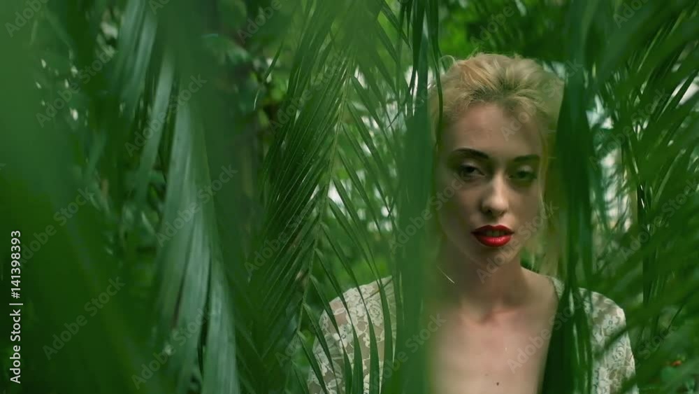Portrait of young woman with beautiful makeup and blond hair enjoying in green tropical forest
Portrait of young woman with beautiful makeup and blond hair enjoying in green tropical forest