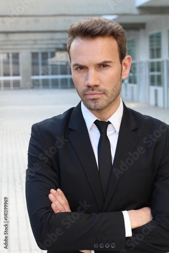 Businessman showing neutral expression closeup with arms crossed 