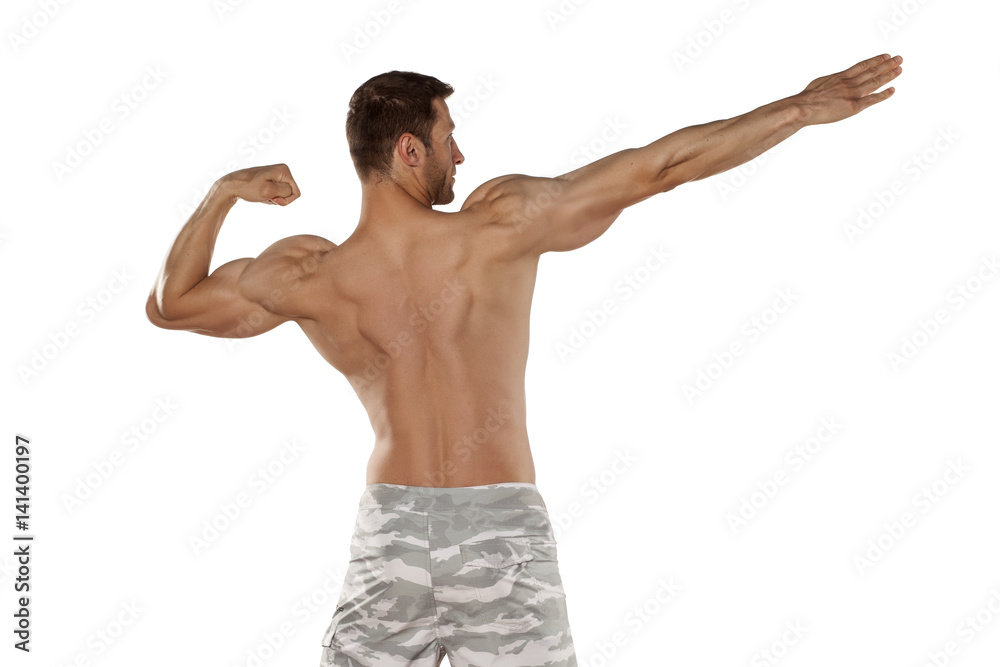 rear view of the half-naked handsome and muscular young man posing on a white background rear view of the half-naked handsome and muscular young man posing on a white background
